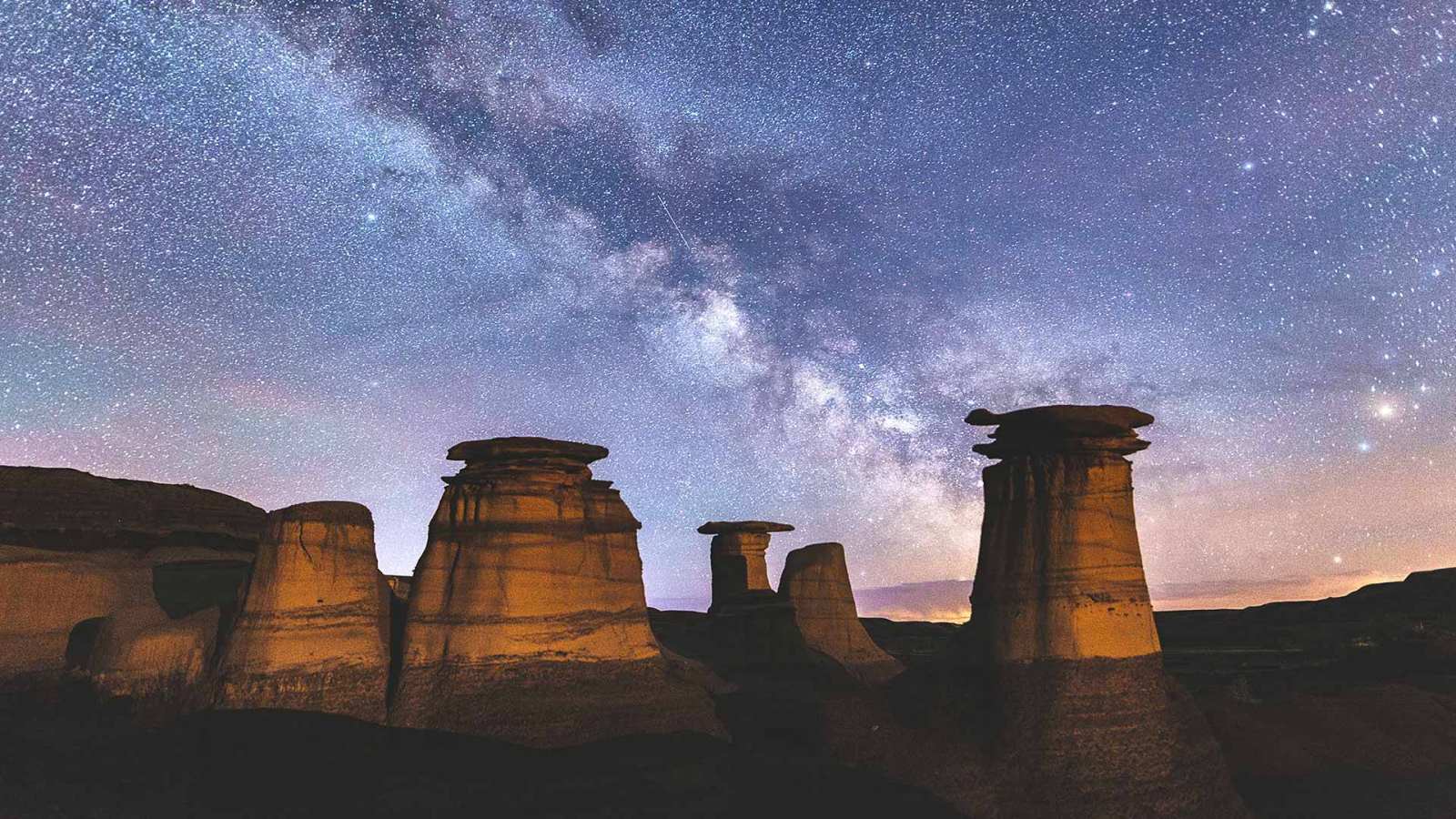 必应壁纸 2020年3月10日 加拿大恶地里石窟上方的银河，加拿大亚伯达省德拉姆黑勒