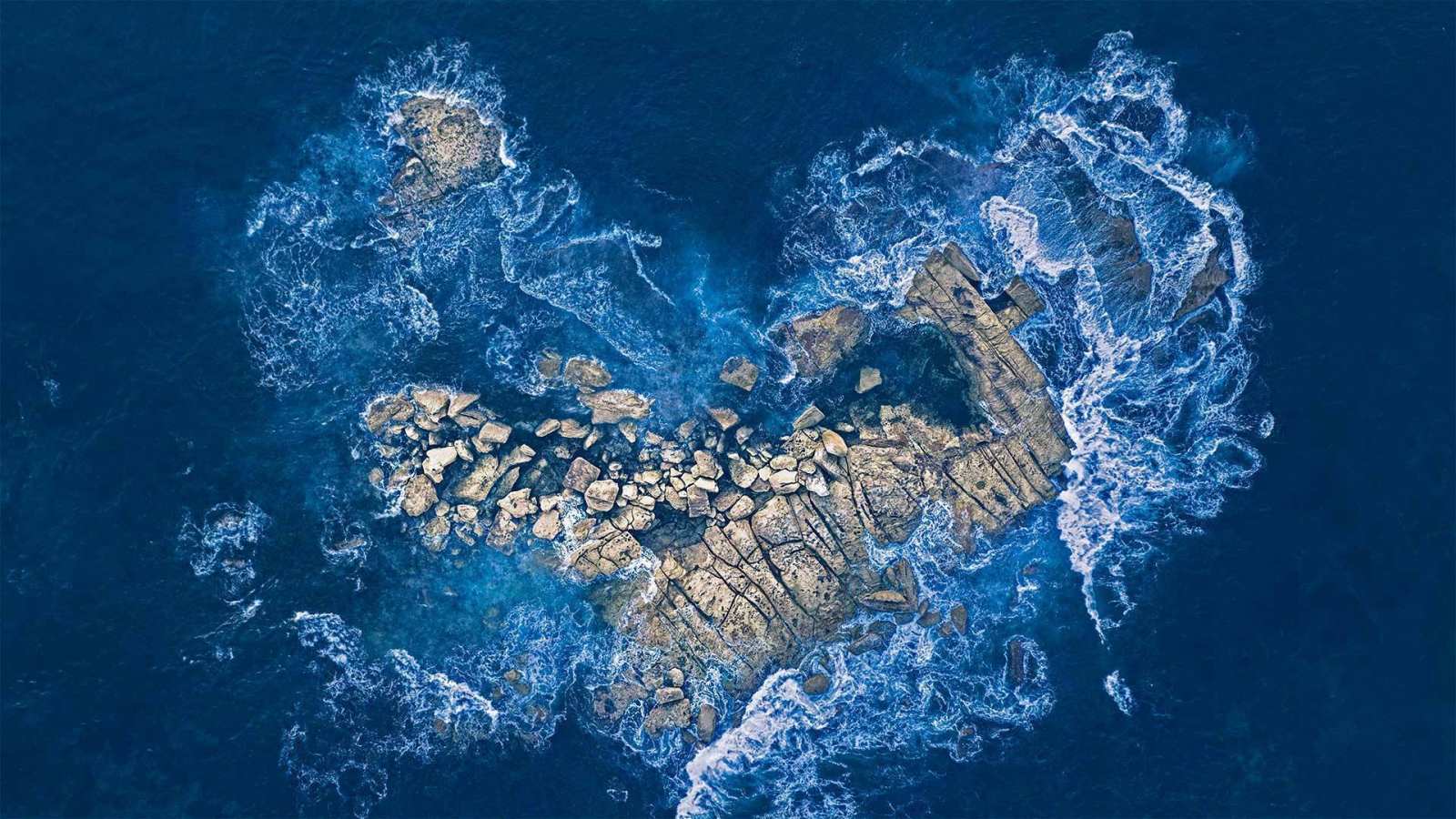 必应壁纸 2021年2月14日 海浪冲击着悉尼海岸的一个心形岩石岛，澳大利亚